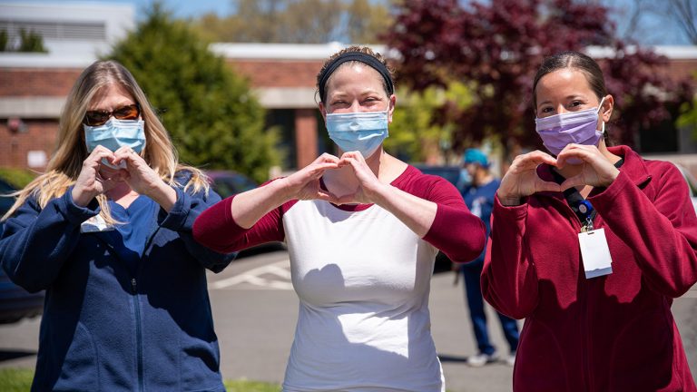 Symbolbild (Drei Pflegekräfte zeigen Hand-Herz-Zeichen) ©Rusty Watson/Unsplash