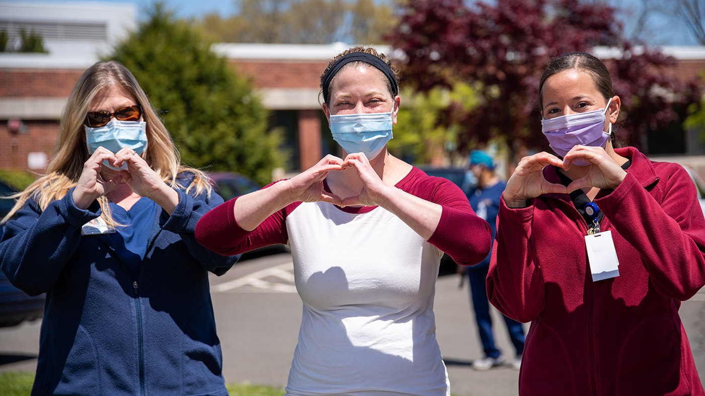Symbolbild (Drei Pflegekräfte zeigen Hand-Herz-Zeichen) ©Rusty Watson/Unsplash